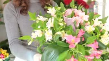 年轻的女花匠在她的商店里做花艺，<strong>专注</strong>于花束